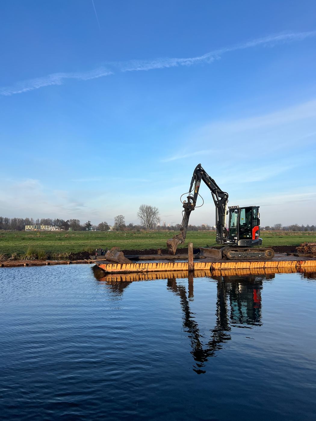 Graafmachine plaatst een beschoeiing langs het water