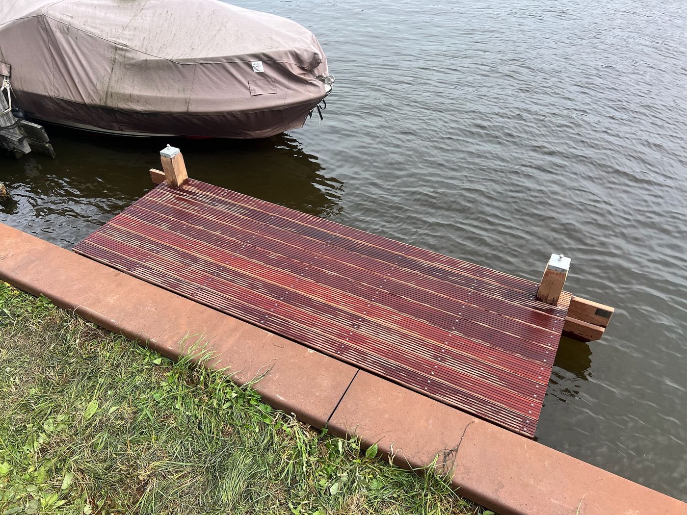Hardhouten steiger met aangemeerde boot